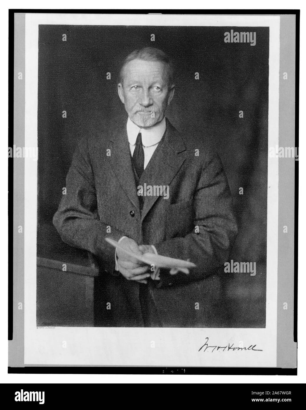 William H. Howell, half-length portrait, standing, facing front, leaning on lectern, holding papers Stock Photo