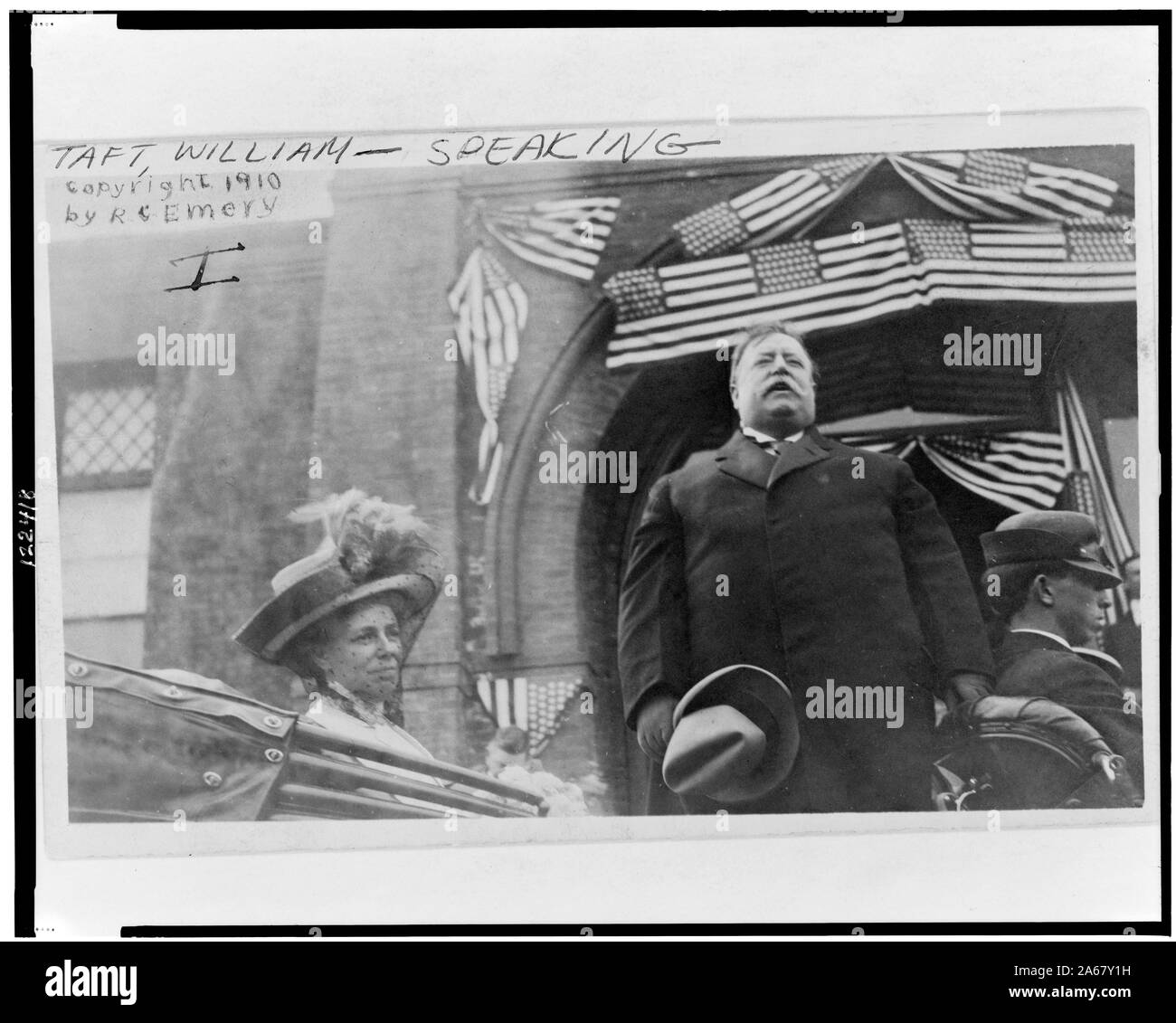 William Howard Taft, half-length portrait, standing in back of open-air car, facing front, speaking, with his wife Stock Photo
