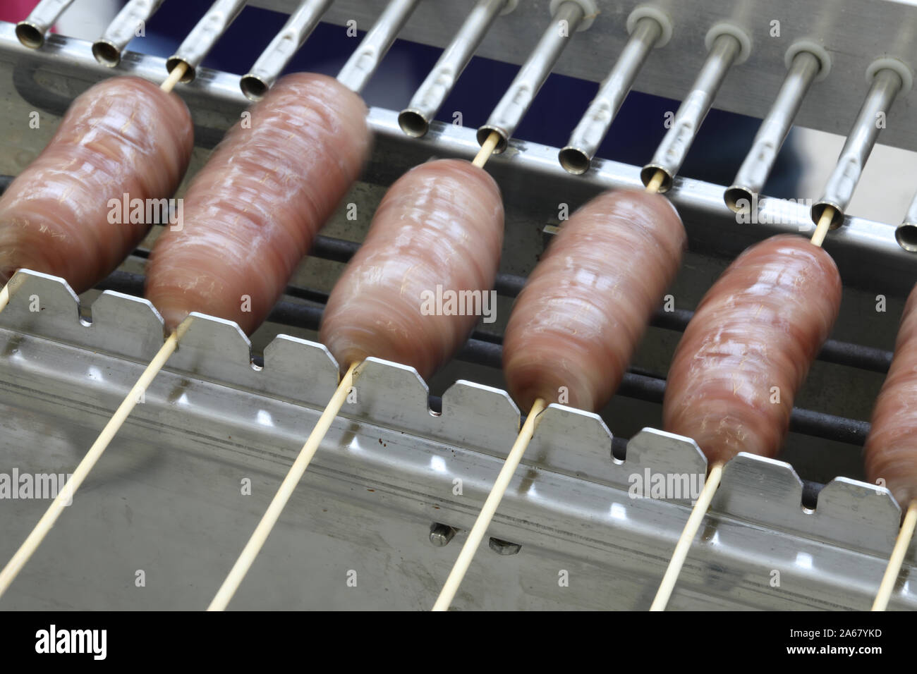 special rotating spit with many sausage of pork Stock Photo - Alamy