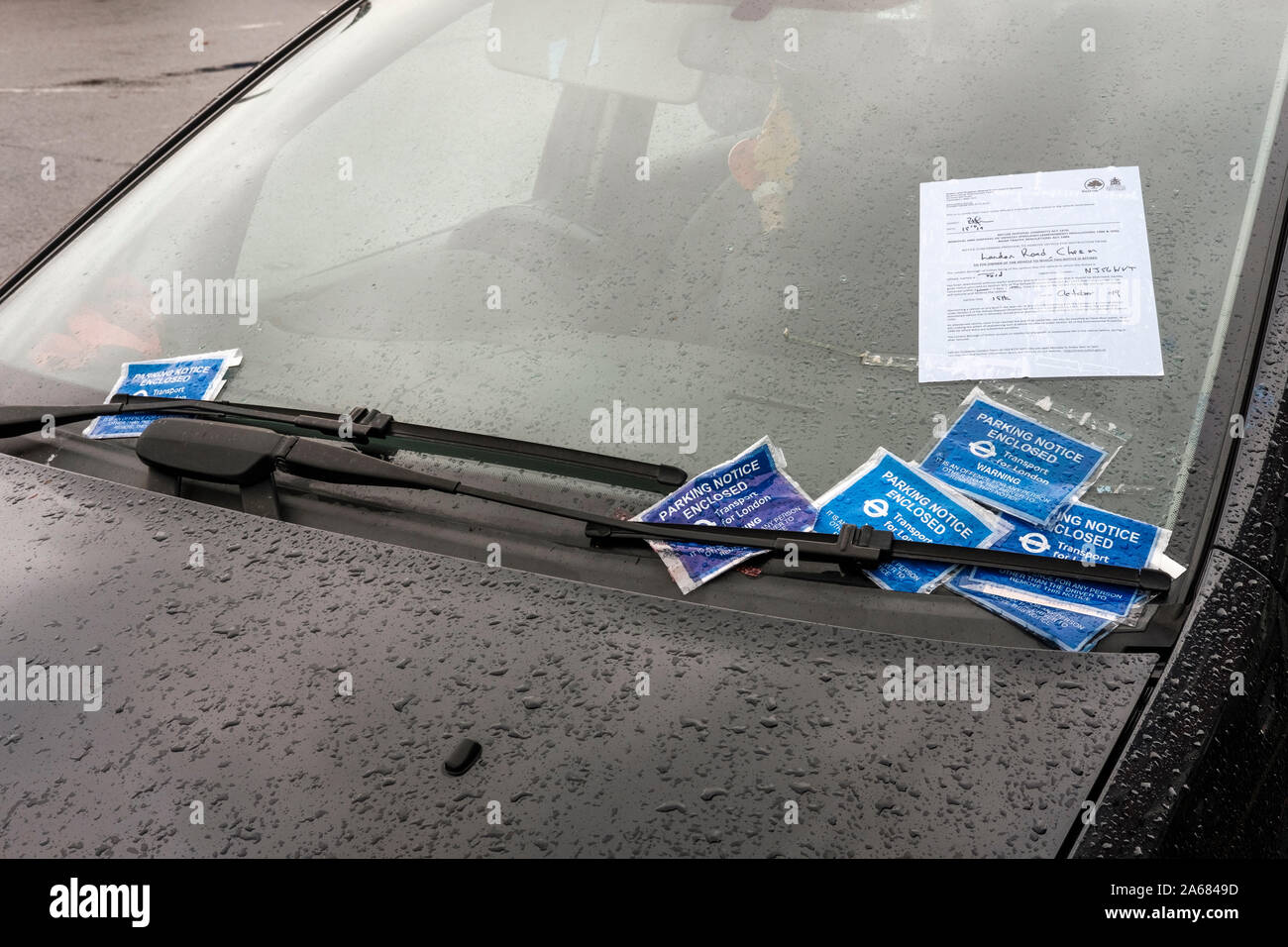 London, UK. Parking tickets and removal and disosal notice  on abandoned vehicle on suburban street  in Greater London.An abandoned vehicle ,once it h Stock Photo