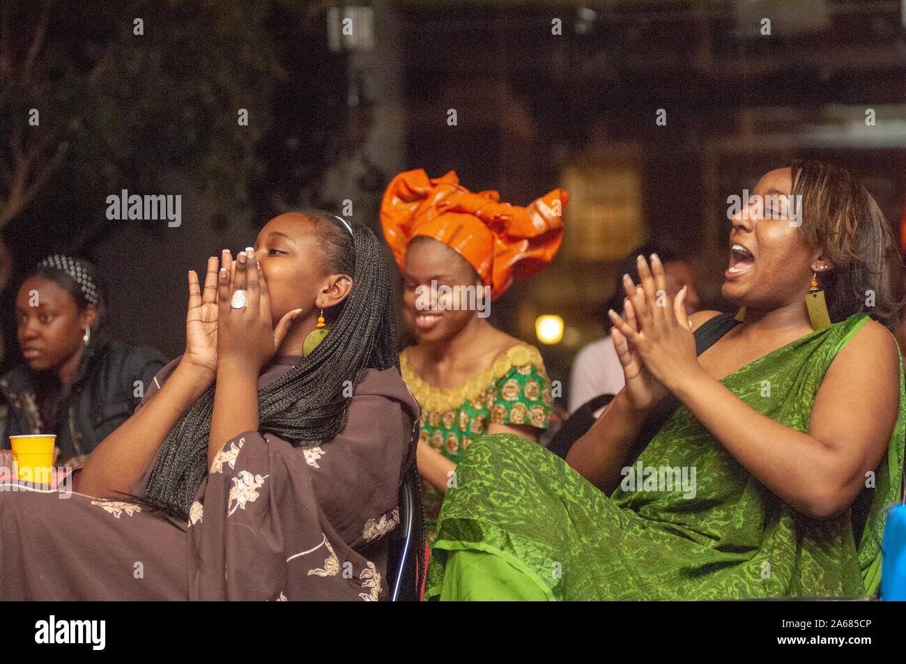 Profile view of seated people, smiling, cheering, and clapping, during an African Students Association (ASA) event at the Johns Hopkins University, Baltimore, Maryland, April 6, 2007. From the Homewood Photography Collection. () Stock Photo