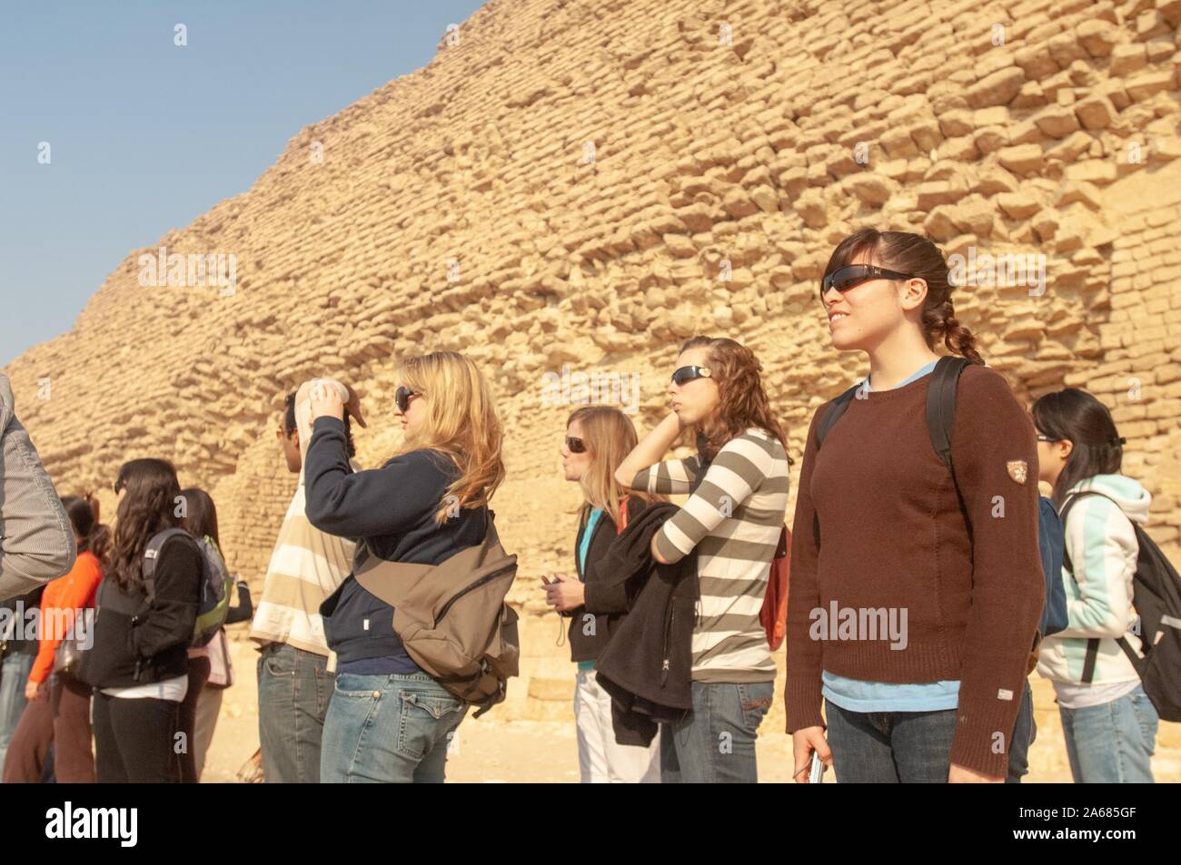 A group of students from the Johns Hopkins University in Baltimore, Maryland, outside on a sunny day, standing in front of a pyramid, Giza, Egypt during a study abroad program, January 6, 2008. From the Homewood Photography Collection. () Stock Photo