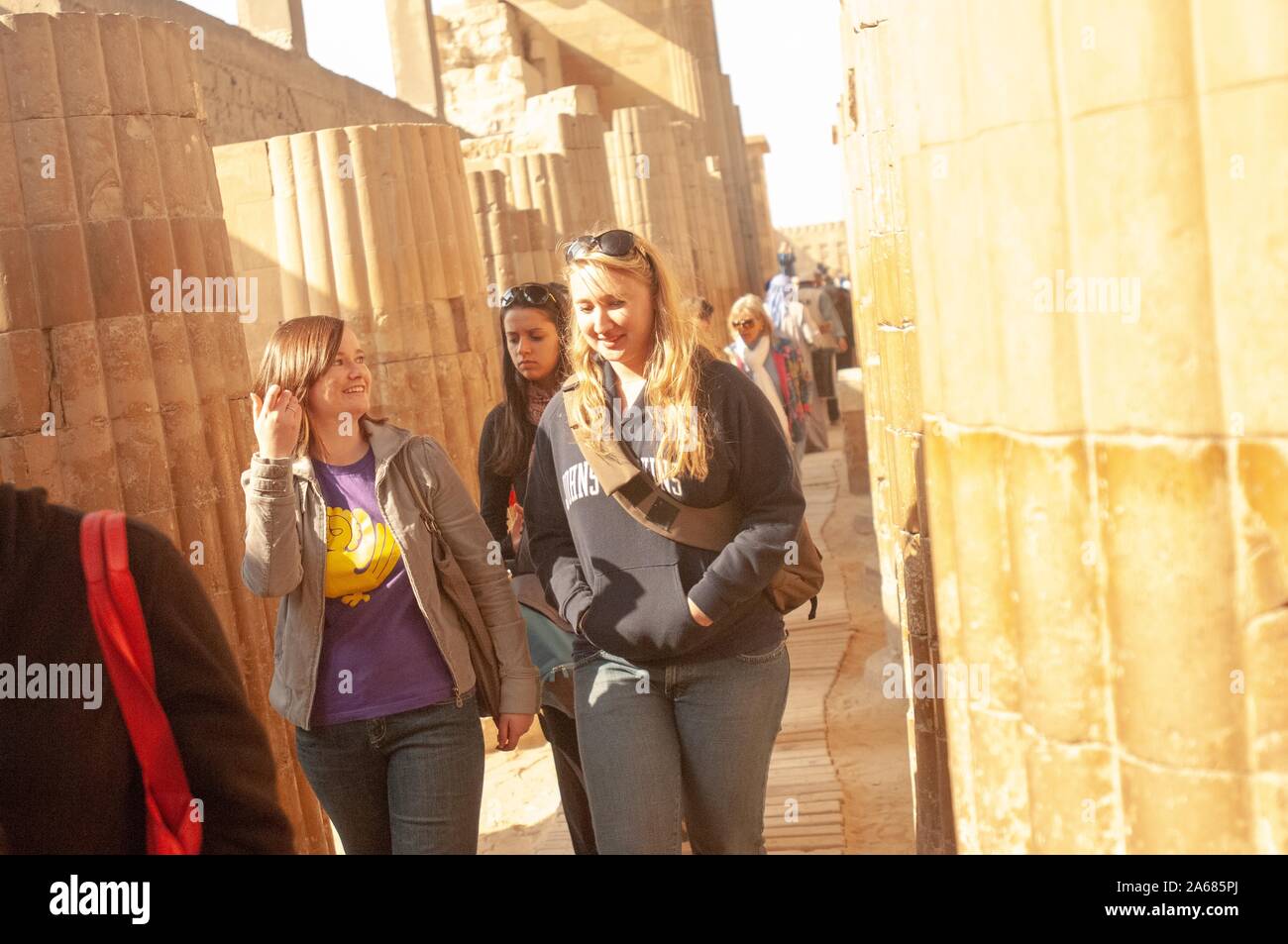 Two Johns Hopkins University students, smiling as they walk along a sunny path, in between massive fluted columns, Giza, Egypt during a study abroad program, January 6, 2008. From the Homewood Photography Collection. () Stock Photo