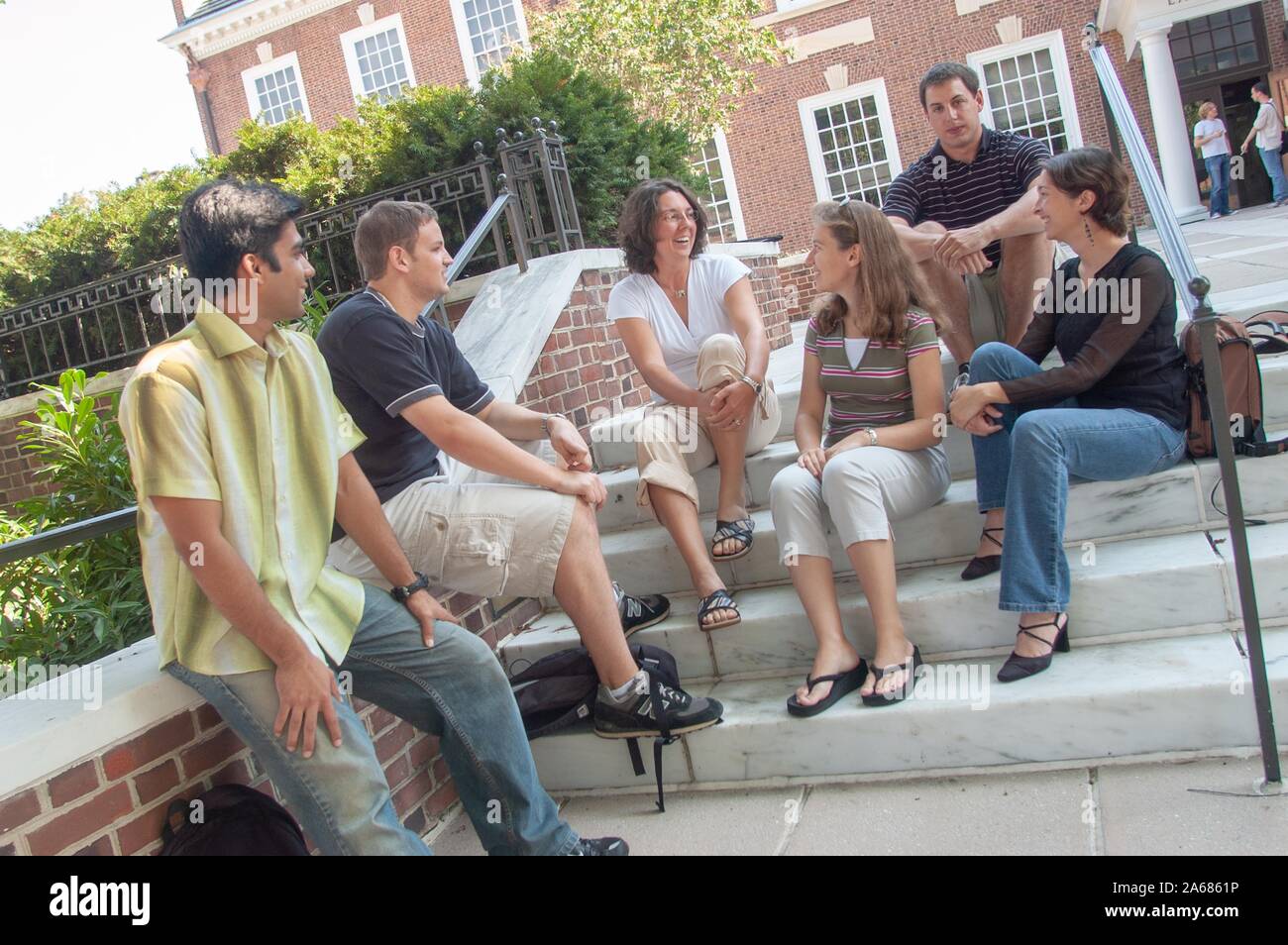 Smiling students, sitting on a shaded set of stairs, outside on a sunny day, on the grounds of the Johns Hopkins University, Baltimore, Maryland, September 19, 2005. From the Homewood Photography Collection. () Stock Photo