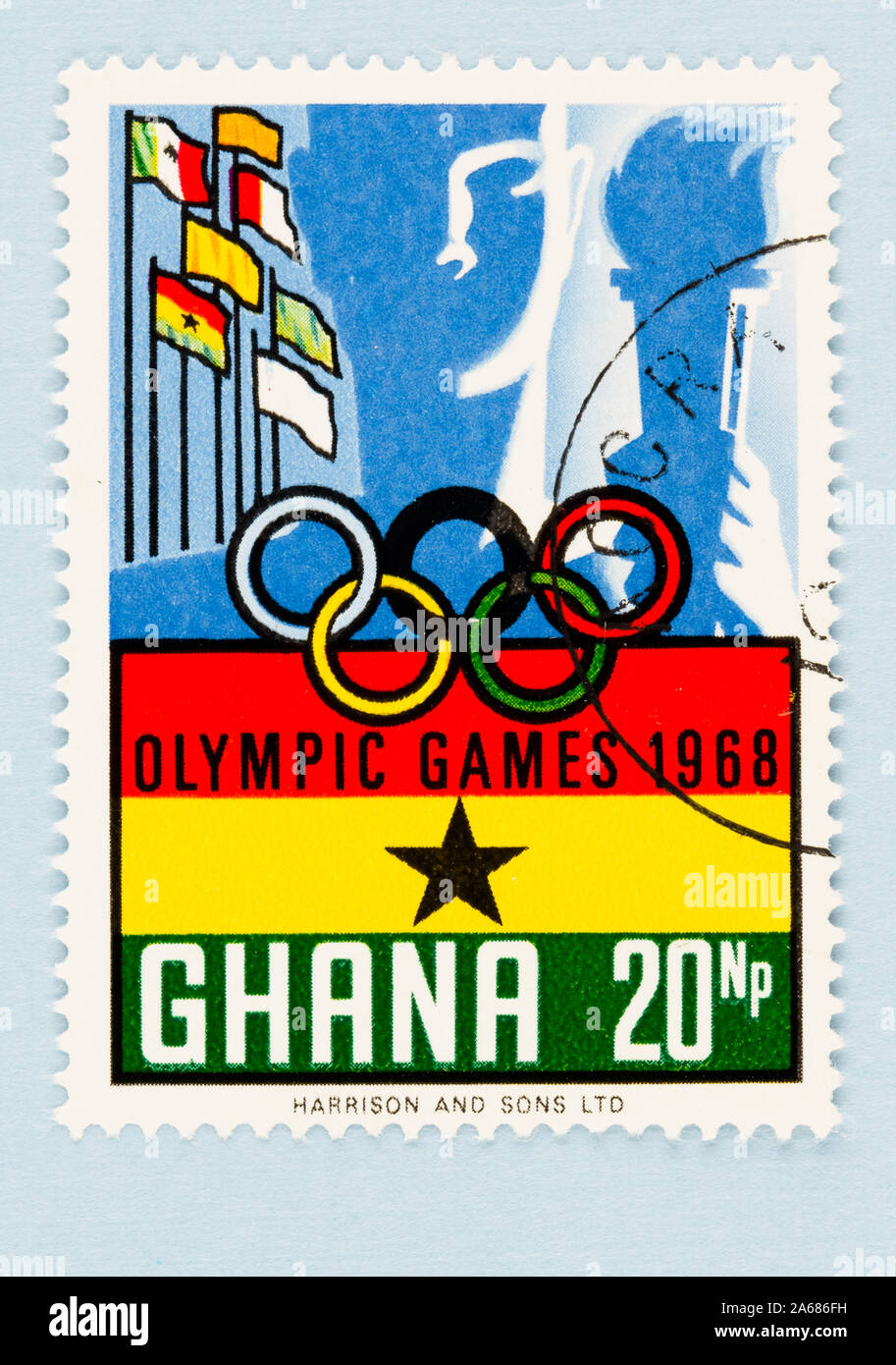 Close up of Ghana postage stamp celebrating the Olympic games in Mexico in 1968. Stamp with Ghana and country flags on blue background with copy space. Stock Photo