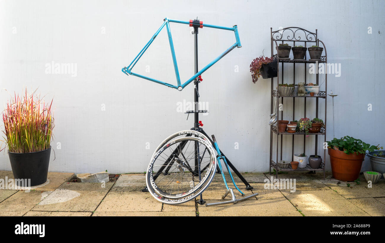 Blue retro bike frame in fornt of a white wall ready for restoration Stock Photo