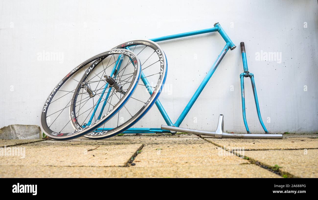 Blue retro bike frame in fornt of a white wall ready for restoration Stock Photo