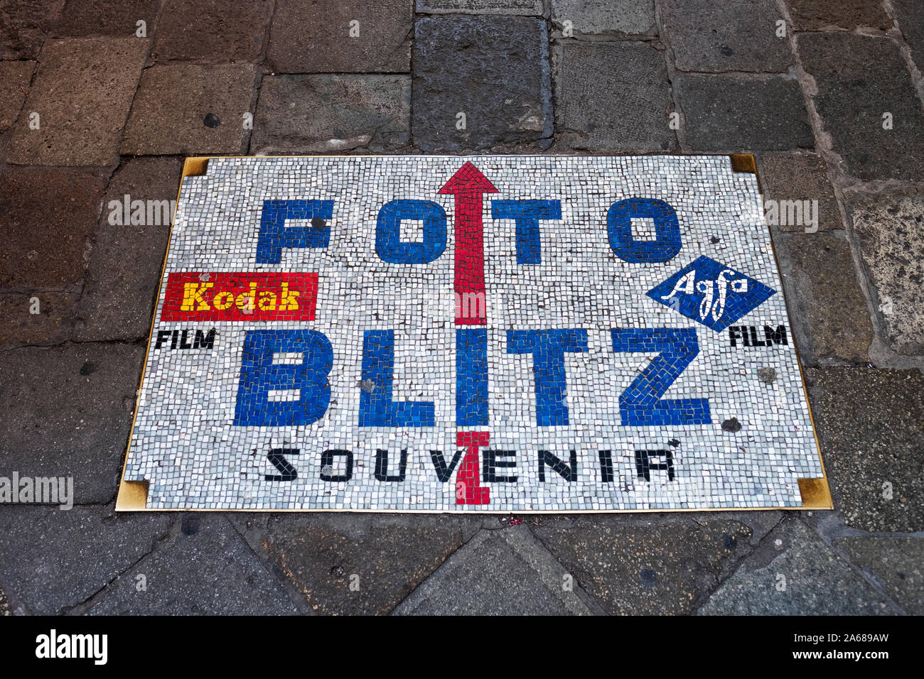 A mosaic sign on the ground pointing tourist & residents to Foto Blitz, a camera, film & digital imaging store on Calle dei Baloni in Venice, Italy Stock Photo