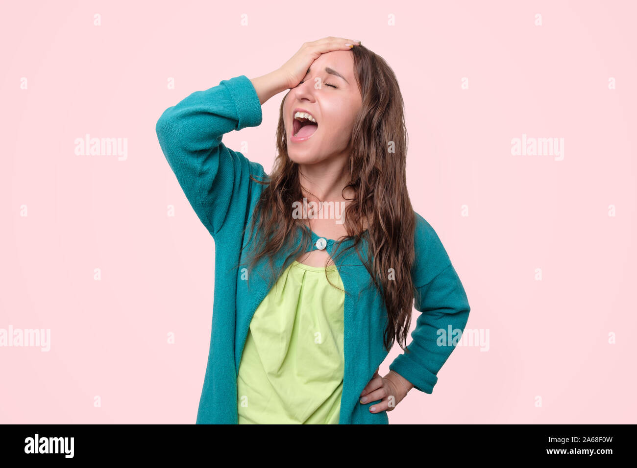 Cheerful laughing young woman touching head. Studio shot Stock Photo
