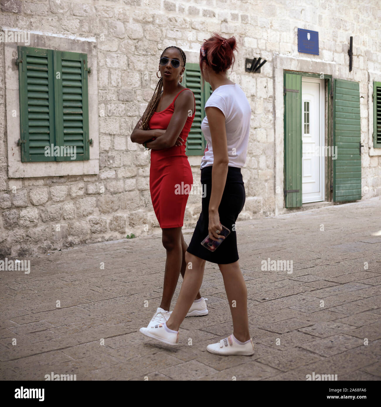 Montenegro, Sep 18, 2019: Two slender women standing and chatting on the street in Kotor Old Town Stock Photo