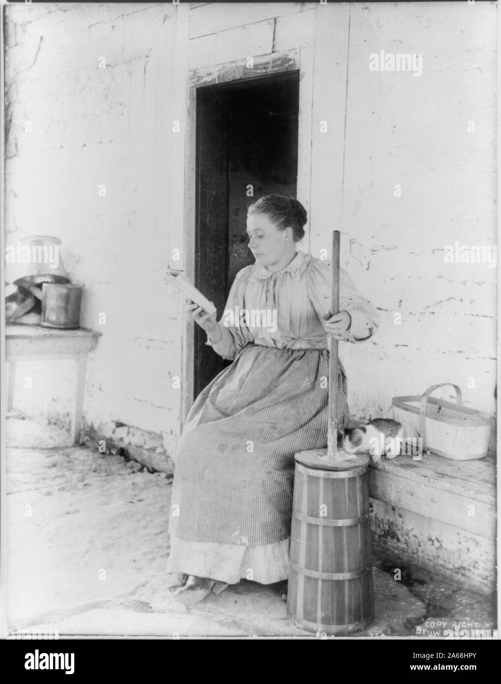 Woman churning milk to butter Stock Photo