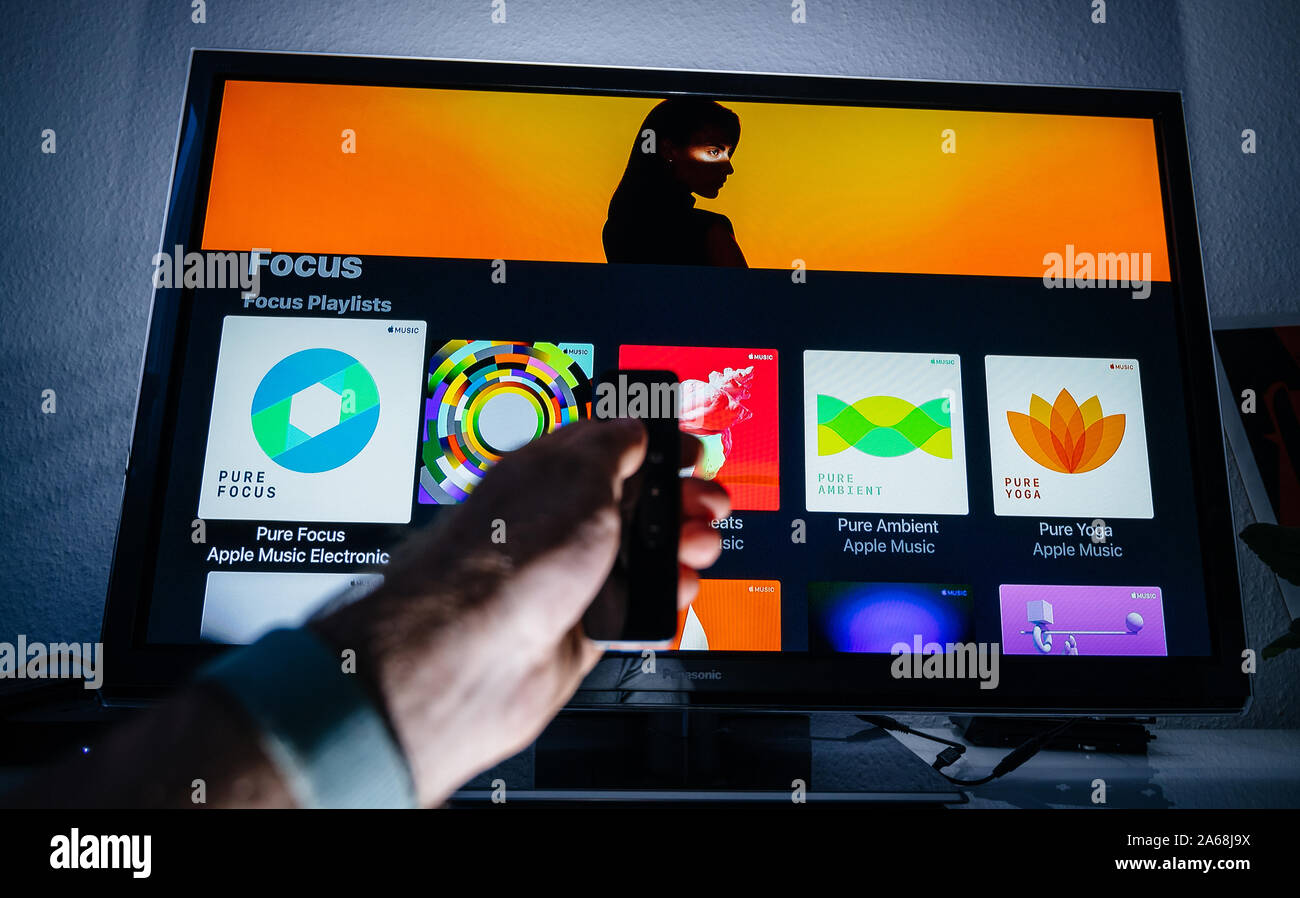 Paris, France - Circa 2019: Man hand holding remote control of Apple TV in  front of Panasonic Plasma tv set in living room with Focus Playlists on  Apple Music Stock Photo - Alamy