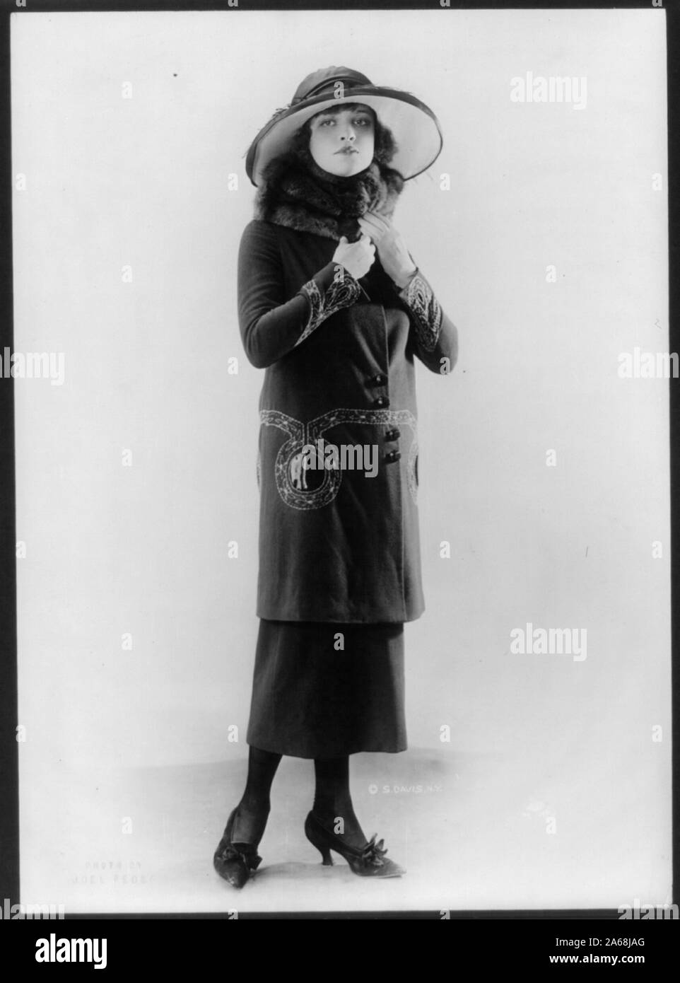 Woman modeling hat and suit with long coat and fur collar Stock Photo -  Alamy