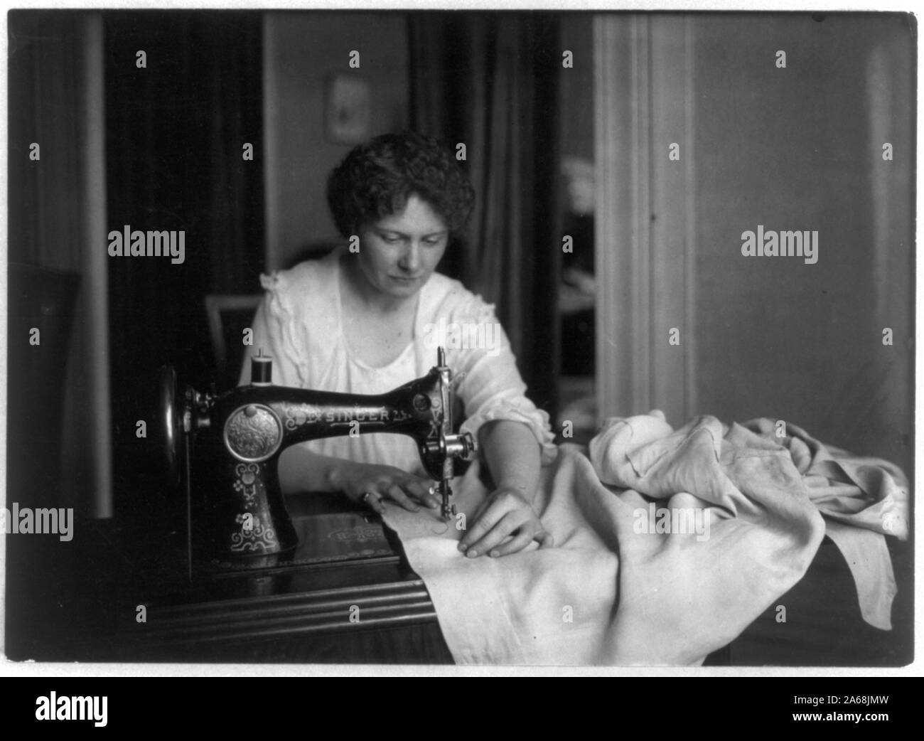 Woman sewing with a Singer sewing machine Stock Photo Alamy