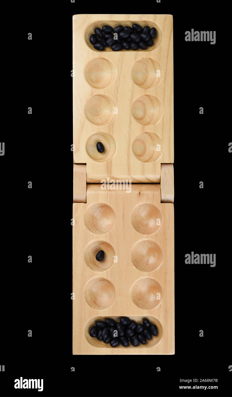 Stones and wooden folding board for playing mancala. The hole for the stones, the game is over. The concept of board games. Stock Photo