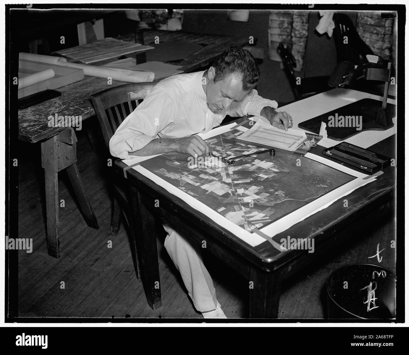 Working of $3,000,000 map. (2) C.E. Kowalozyk, AAA worker, using a planimetor, which measures the exact acreage in each section of land surface photographed, 7/28/37 Stock Photo