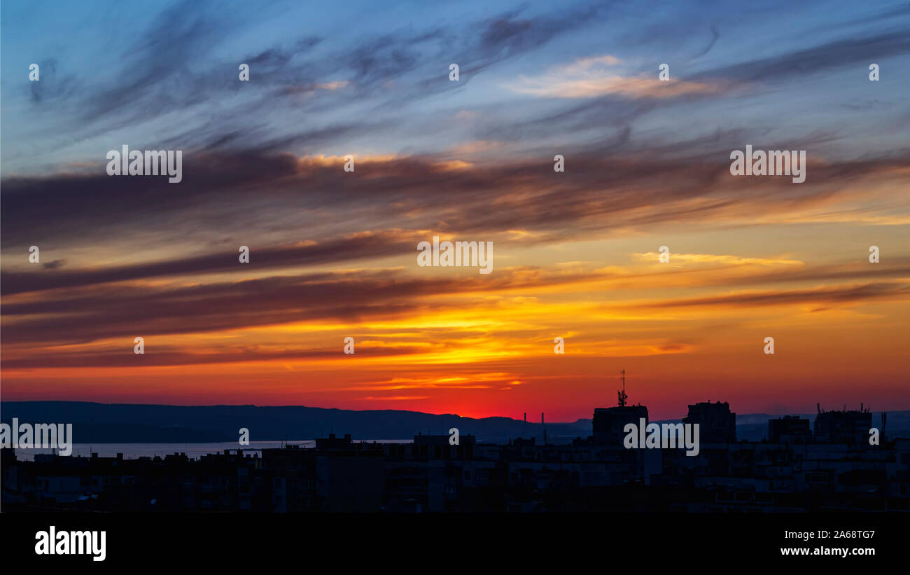 Scenic sunset afterglow over a city. Vivid sky of orange and blue colors during sundown. Beautiful skyscape at the sunset. Beauty in nature. Stock Photo