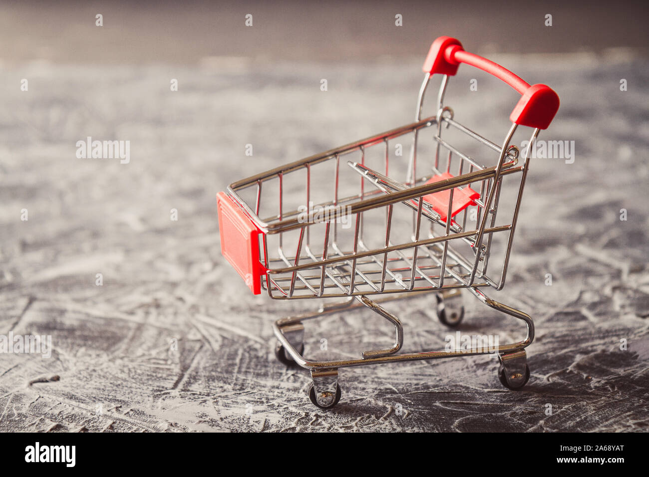 Empty shopping cart on gray background. Side view Stock Photo