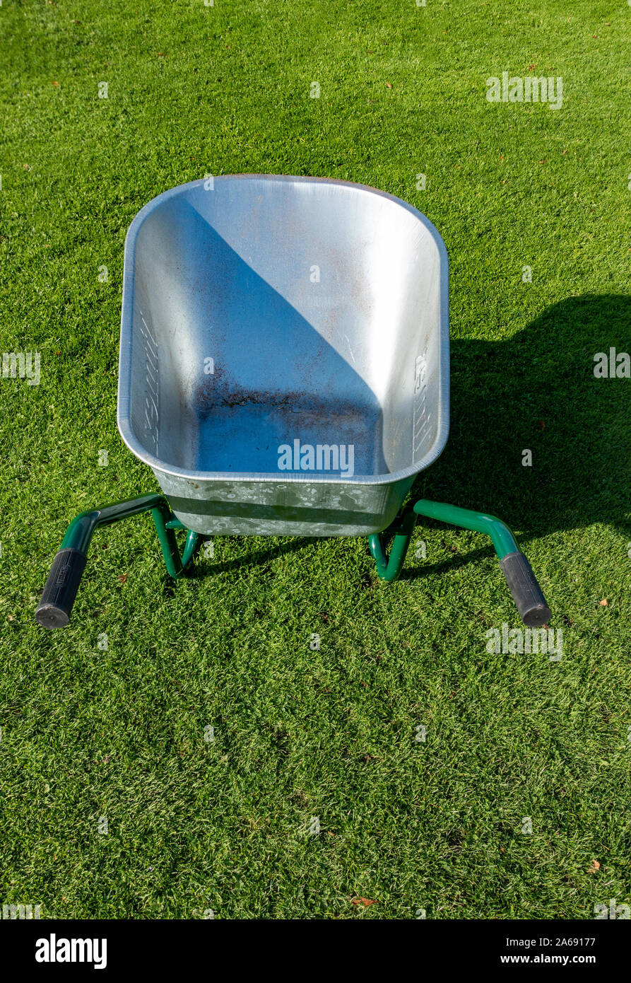 New Aluminium Wheel Barrow on neat lawn Stock Photo