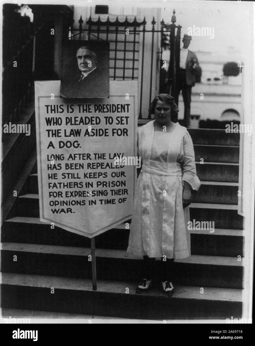 Young women picketing outside White House gates for amnesty for war protesters - sign, with portrait of Harding, reads: This is the president who pleaded to set the law aside for a dog. Long after the law has been repealed he still keeps our fathers in prison for expressing their opinions in time of war Stock Photo