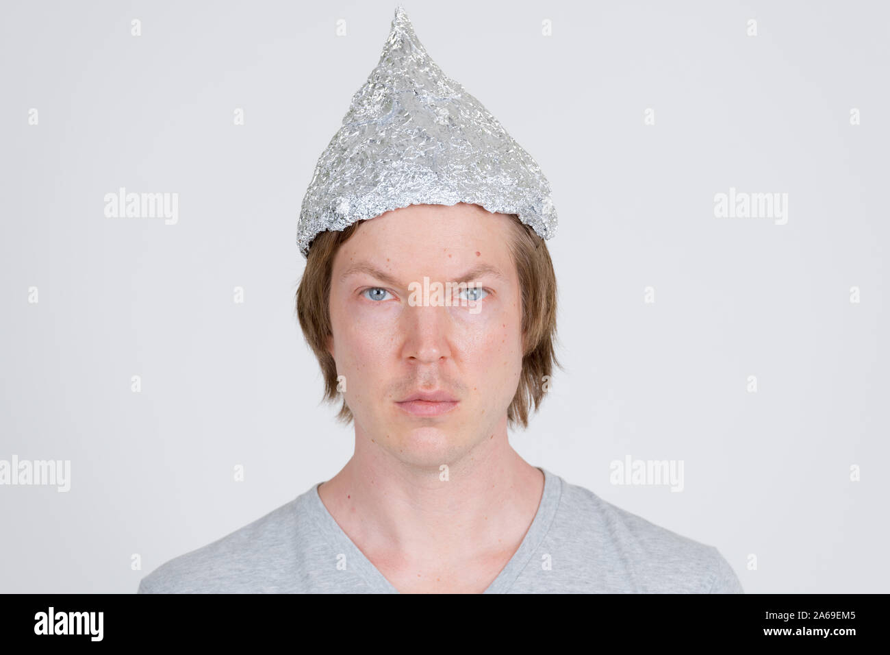 Face of young man with tinfoil hat as conspiracy theory concept Stock Photo