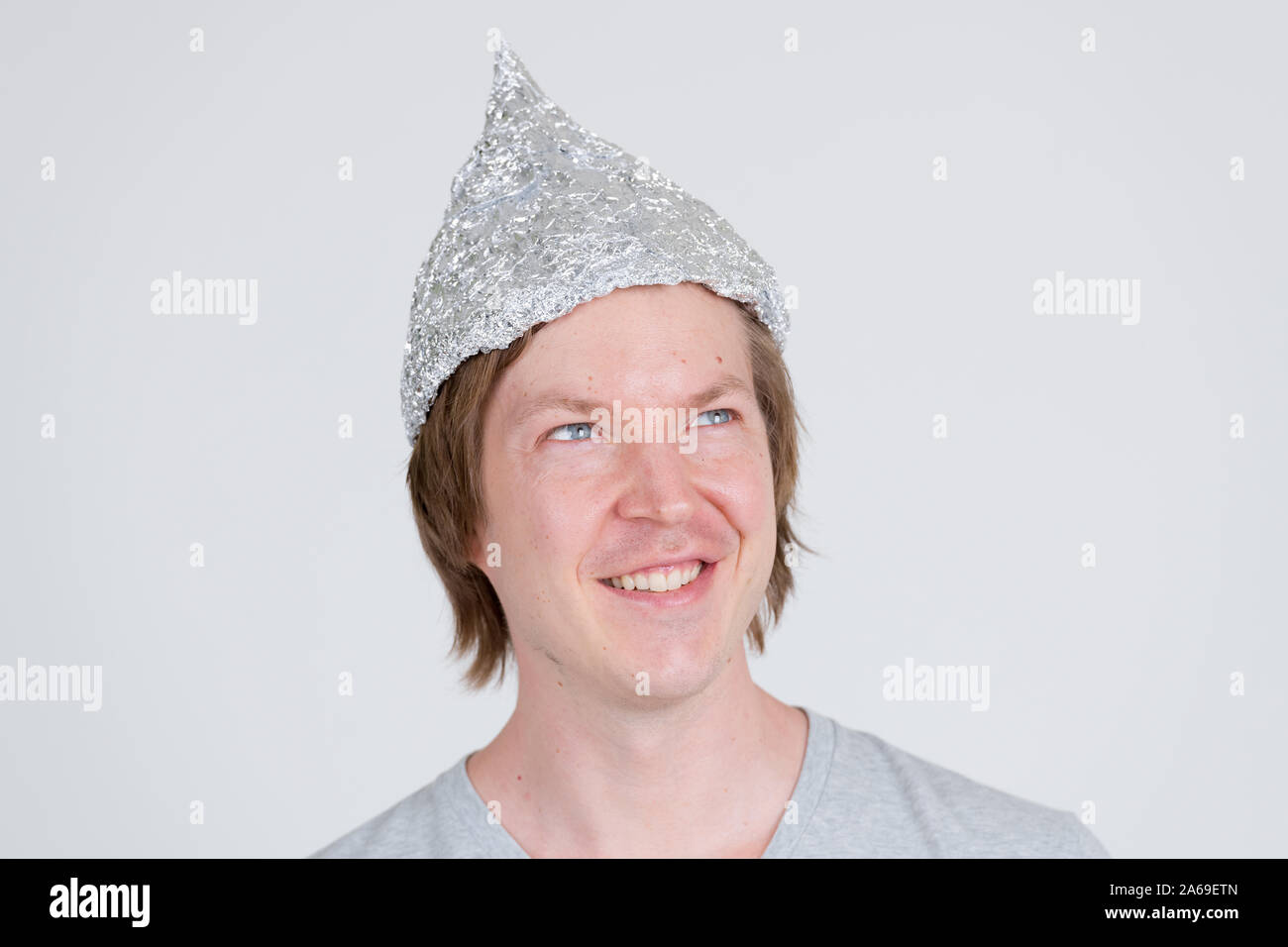 Face of happy young man with tinfoil hat thinking as conspiracy theory concept Stock Photo Alamy