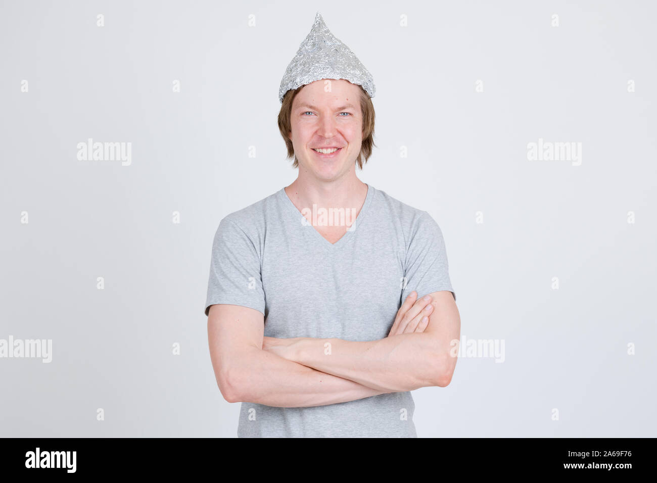 Happy young man with tinfoil hat as conspiracy theory concept Stock Photo