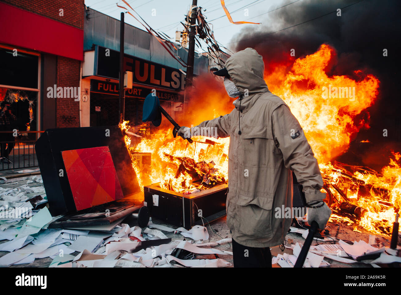QUILPUE, CHILE - OCTOBER 20, 2019 - Protester poses with part of a uniform looted from a Bank during the protests of the 'Evade' movement against the Stock Photo