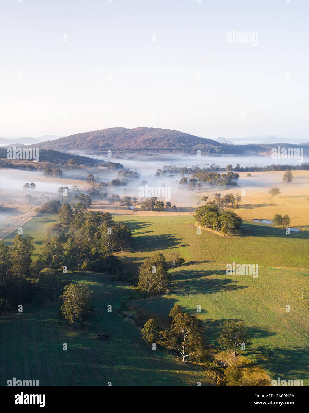 Aerial view over a morning fog and countryside landscape. Beautiful fields at sunrise Stock Photo