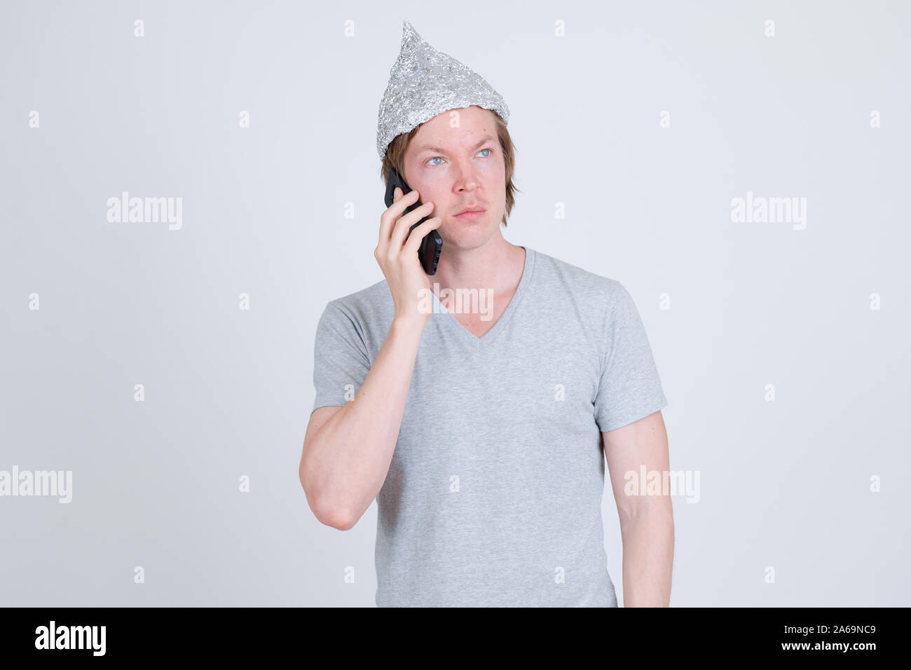 https://c8.alamy.com/comp/2A69NC9/young-man-with-tin-foil-hat-thinking-while-talking-on-the-phone-2A69NC9.jpg