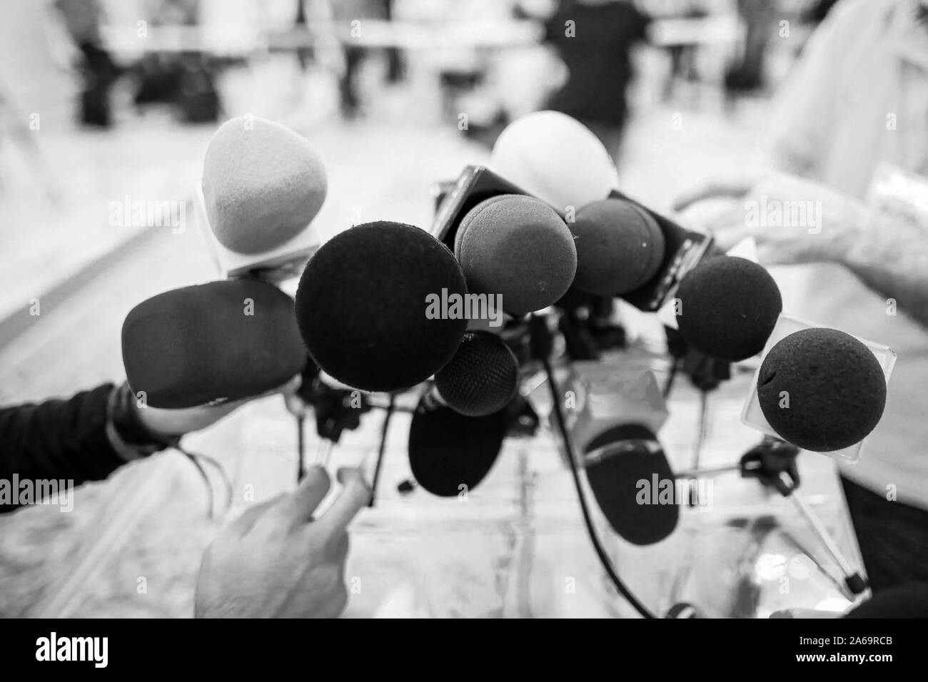 Shallow depth of field image with microphones installed by journalists at a press conference - politician point of view Stock Photo