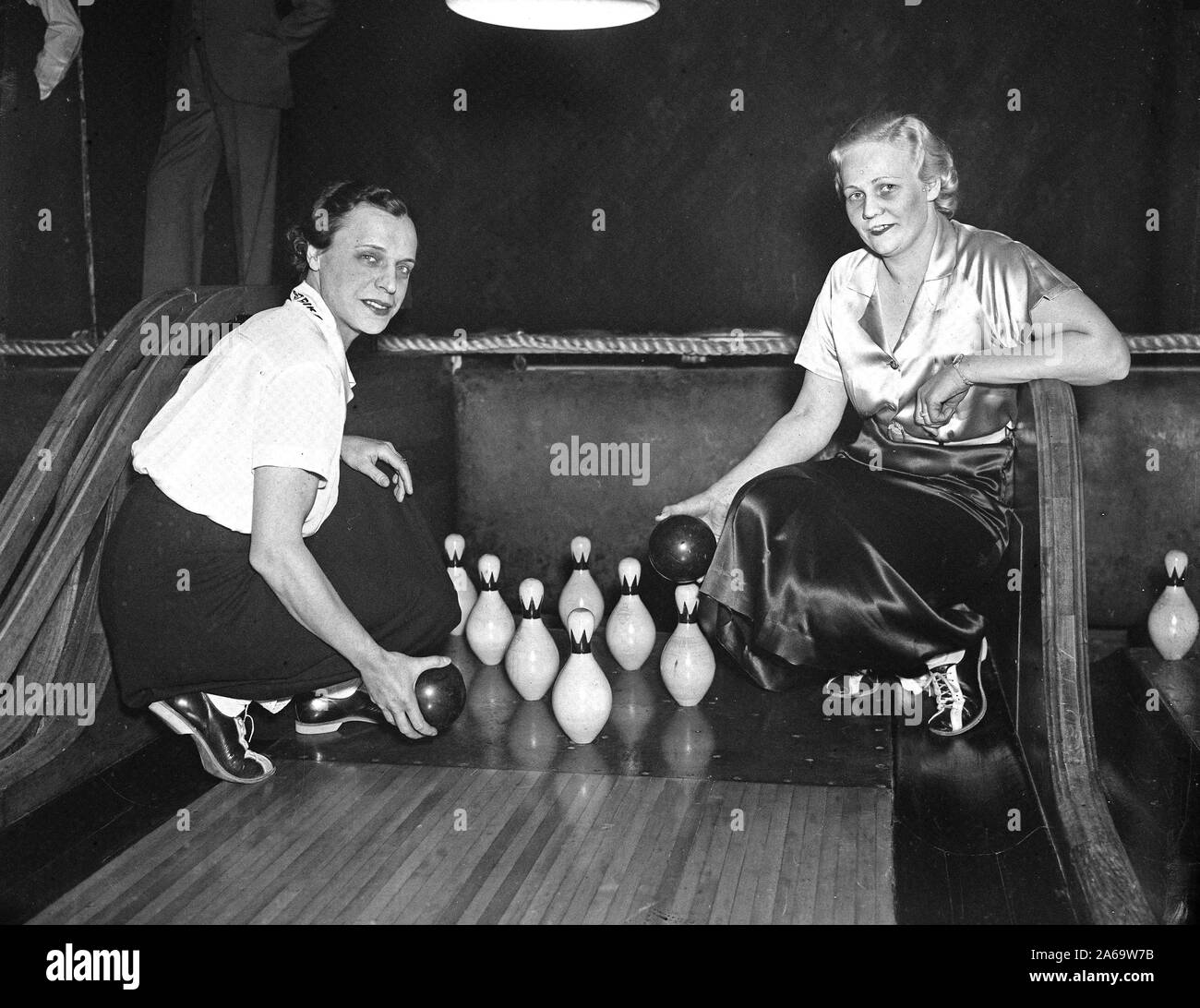 Women in a bowling alley holding balls by the pins ca. 1936 Stock Photo