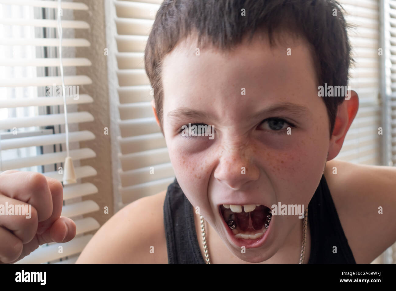 Agressive young boy venting anger with a closed fist. Stock Photo