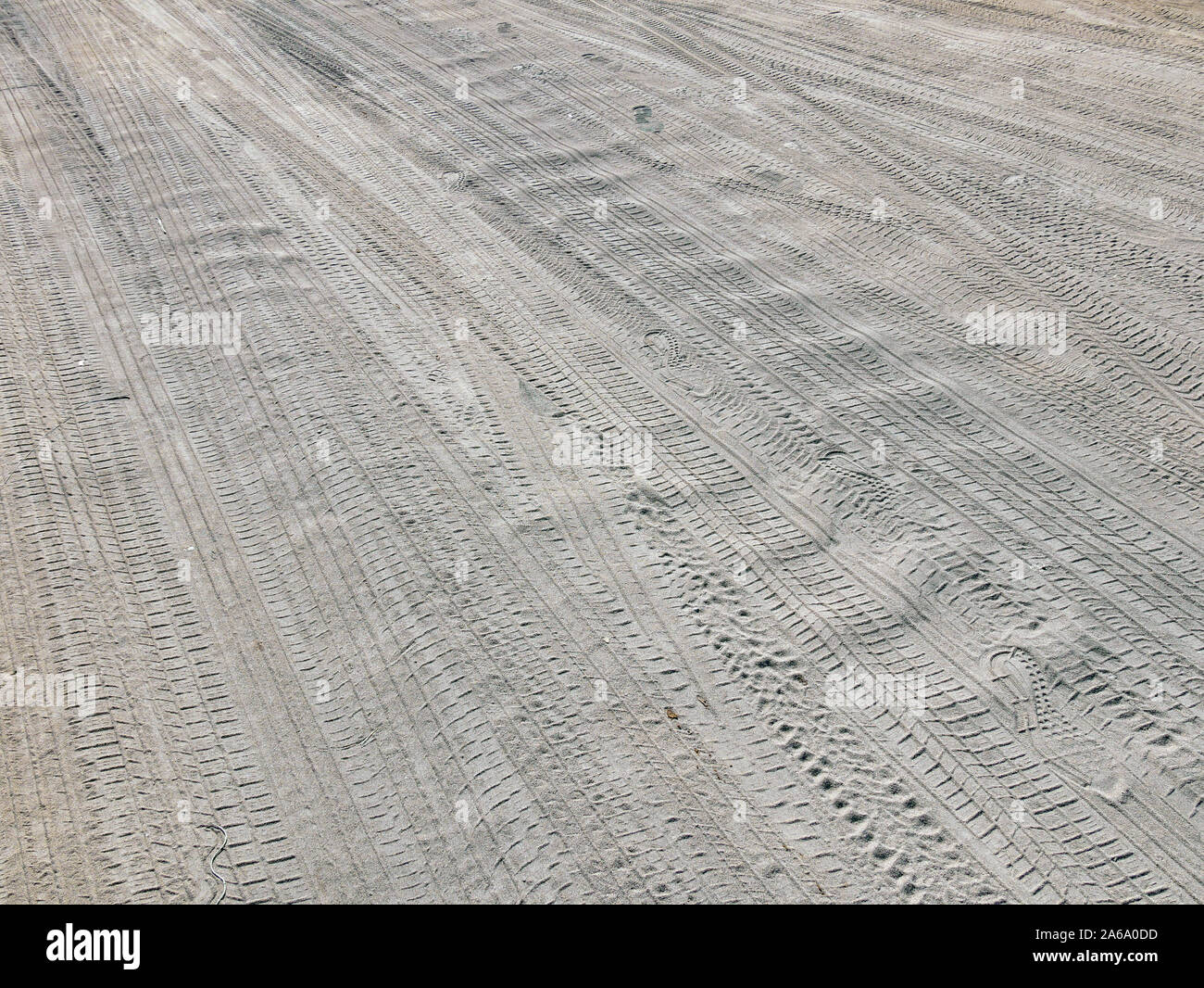 Sandy road. Traces of different tires printed in the sand. Human steps. Closeup photo. Stock Photo