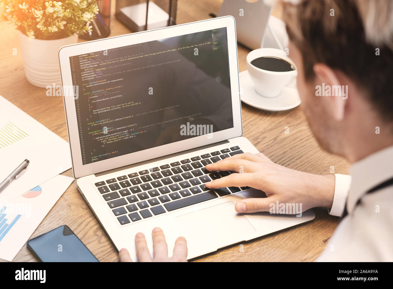 Programmer working on code in office. Man working on laptop. Stock Photo