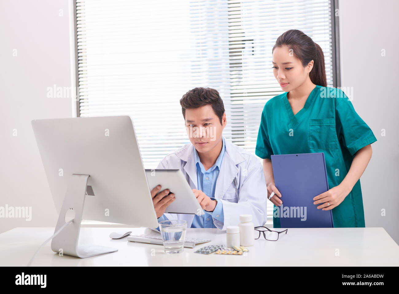 Two medical doctors consulting, smiling at office desk Stock Photo Alamy