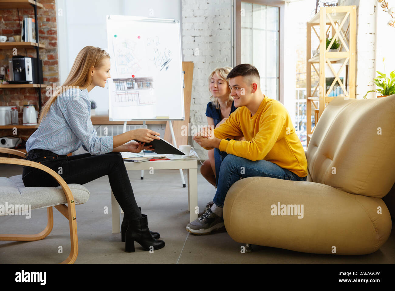 Interior designer working with young couple. Lovely family and ...