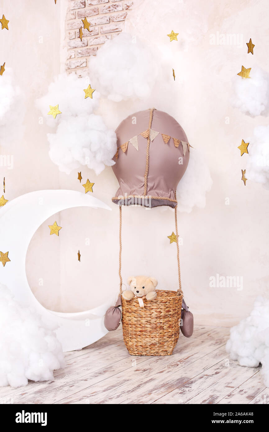 Teddy bear traveler and pilot. Stylish vintage children's room with aerostat, balloons, textile clouds and the moon. Children's location Stock Photo