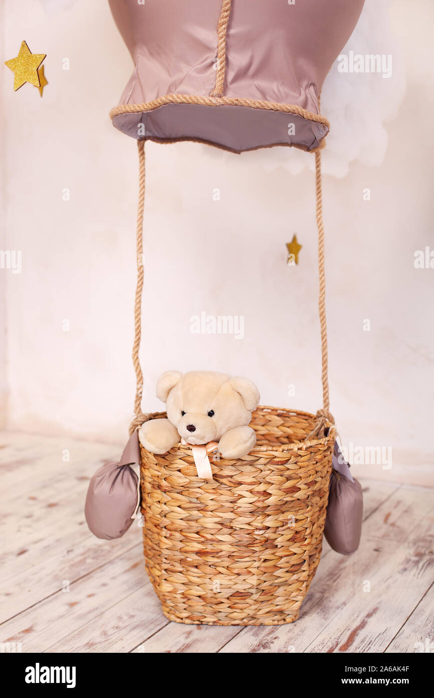 Teddy bear sitting in the balloon basket, aerostat. Children's room and play room decor. The child plays the traveler. Stock Photo