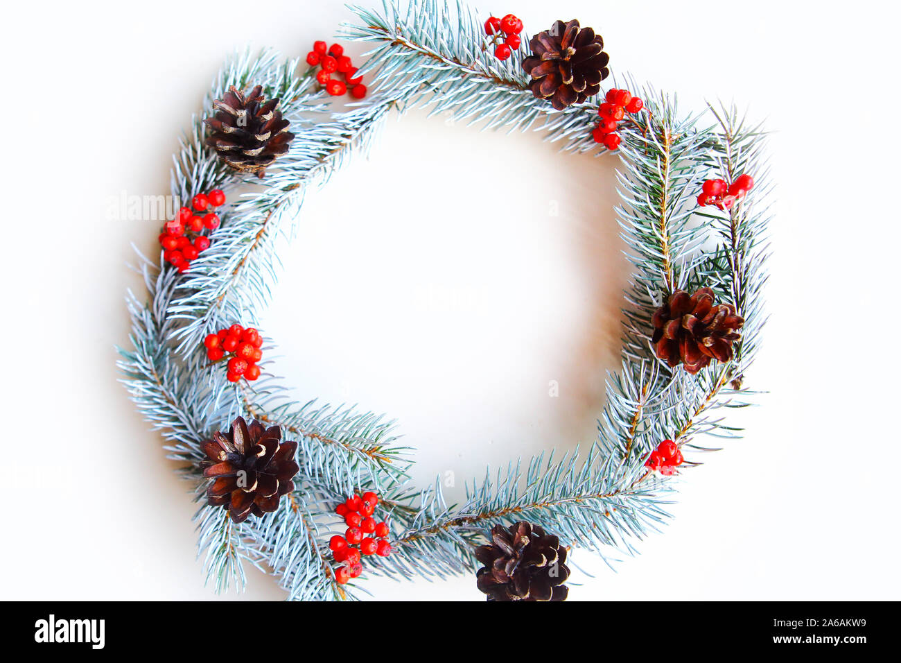 Christmas wreath with pine cones and rowan berries on white background ...