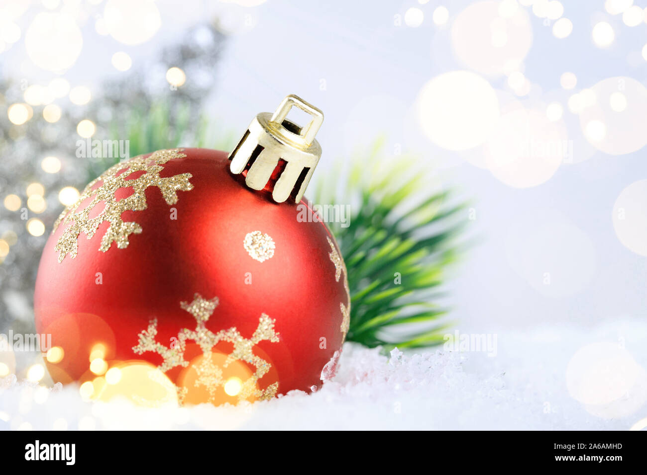 Christmas red ball on snow with golden stars on blue background. Close ...