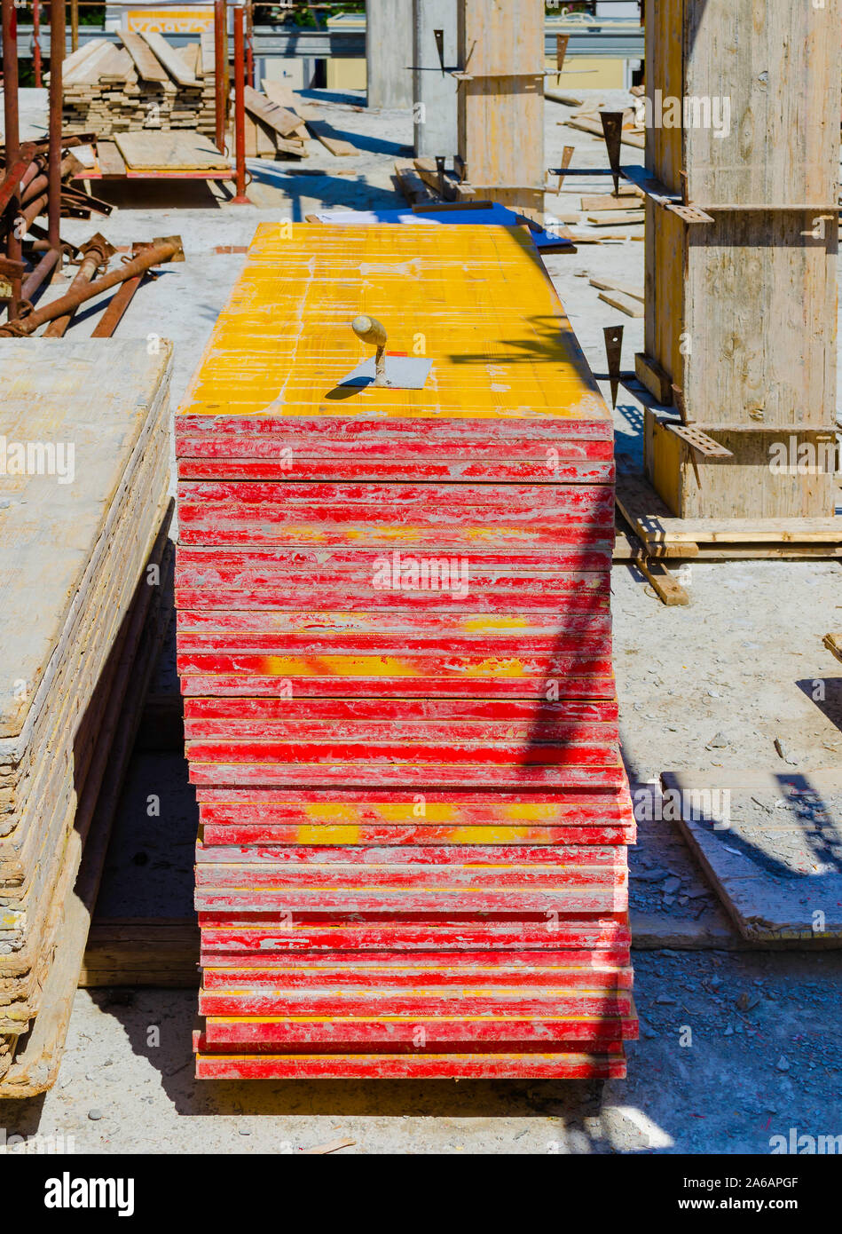 yellow wood panels, trowel and other materials stacked on site Stock