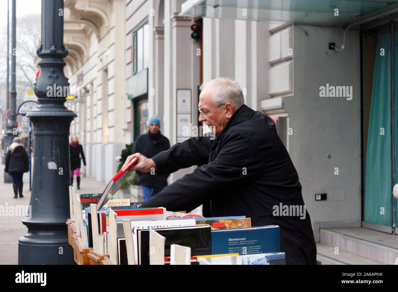 An elderly gentleman browsing books in a street book stand in Vienna, Austria. Stock Photo