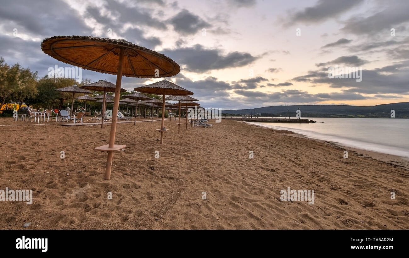 Reed parasols on empty peleponnese beach at sunrise Stock Photo