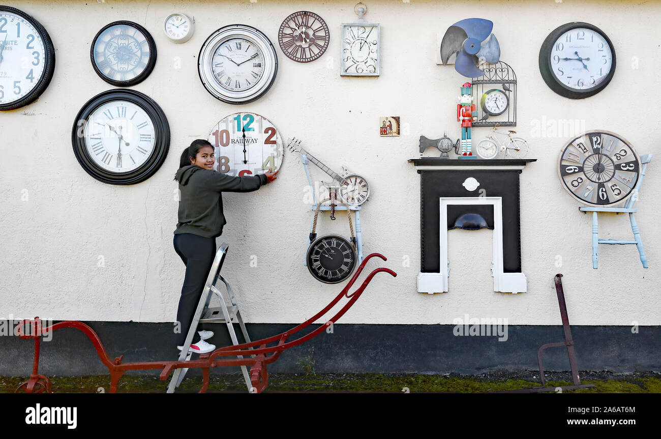 Sky Sangari Phunman changes the time on the clocks at her home in Kill, Co Kildare, ahead of clocks going back one hour. The wall of her home is covered in clocks from around the world that have been collected in memory of her grandfather who was a horologist. Stock Photo