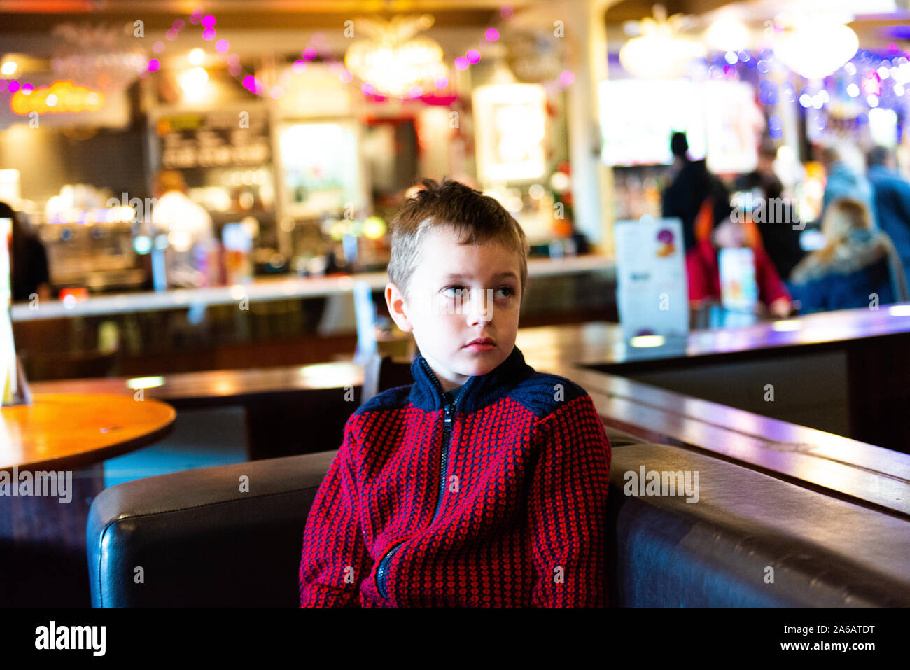 A handsome little boy with adhd, autism, apserger syndrome sits in a