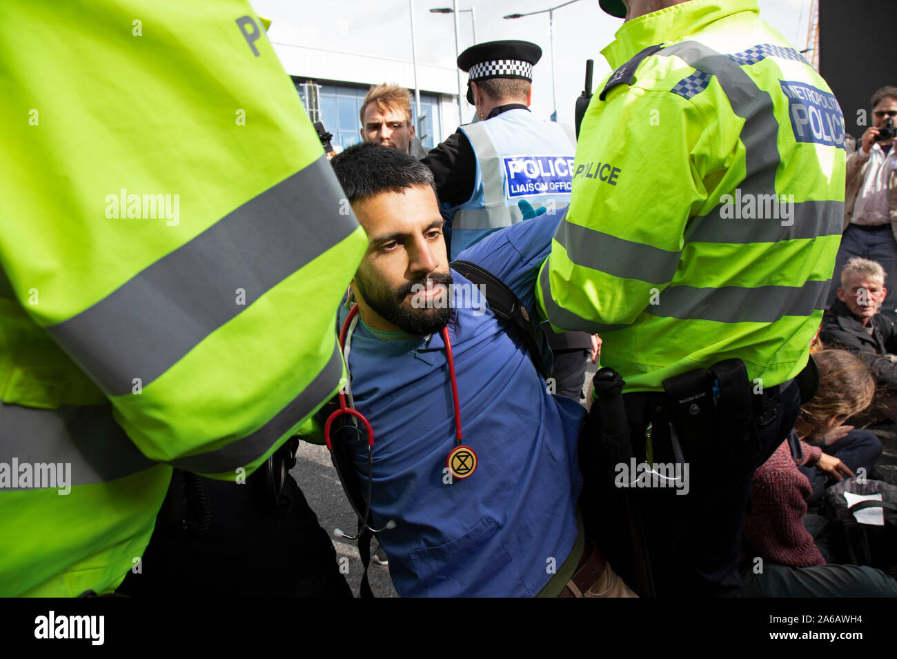 Police read section 14 notices and arrest protesters during Extinction Rebellion disruption outside City Airport on 10th October 2019 in London, England, United Kingdom. The protest is against the climate and pollution impact of the government’s plans for airport expansion which will potentially double the amount of flights coming from City Airport. Extinction Rebellion is a climate change group started in 2018 and has gained a huge following of people committed to peaceful protests. These protests are highlighting that the government is not doing enough to avoid catastrophic climate change an Stock Photo
