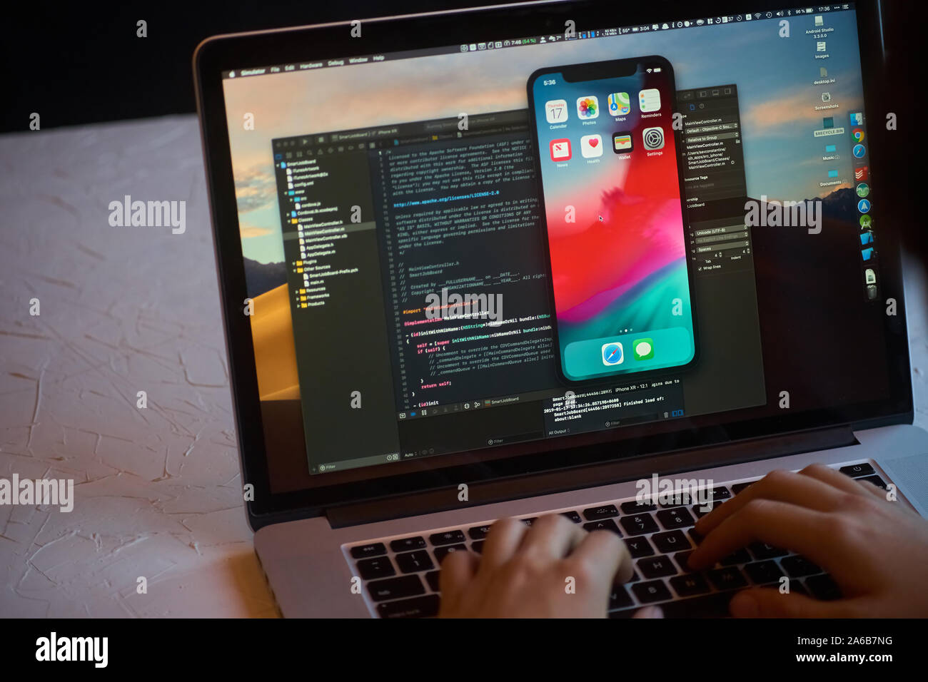Bishkek, Kyrgyzstan - January 17, 2019: Man developer launches xcode software and ios simulator program to develop ios app on a MacBook Stock Photo