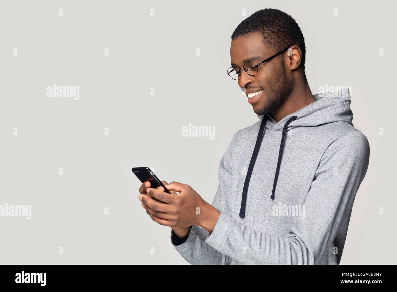 Side view smiling African American man using phone, chatting online Stock Photo