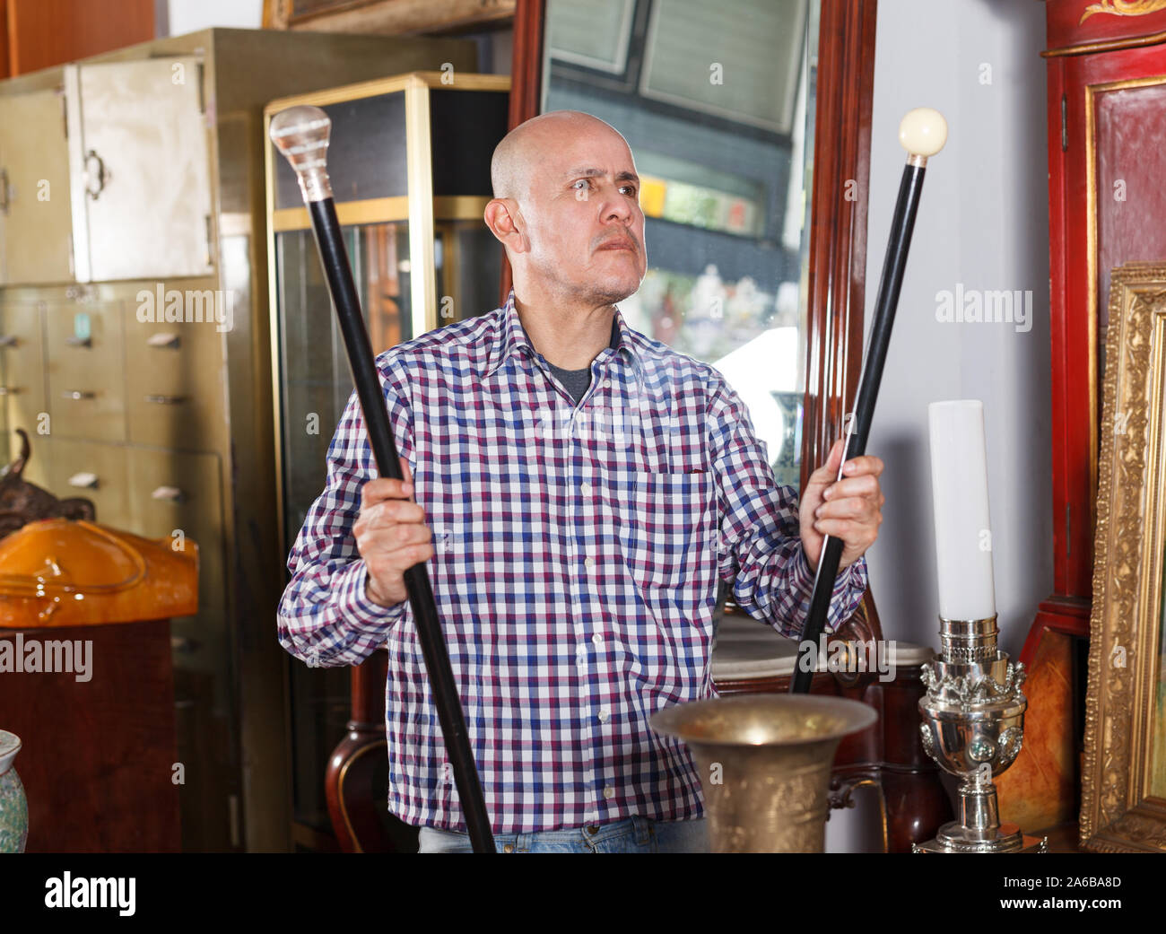 Intelligent middle aged man looking for retro goods in antique store Stock Photo